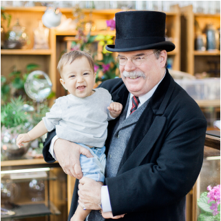 Gregg dressed as Teddy Roosevelt, holding a grandchild