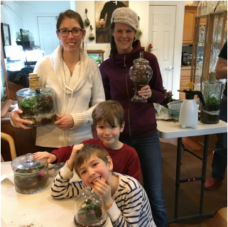 A pair of moms and their kids with finished terrariums