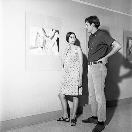 Two students next to painting in art gallery, 1967